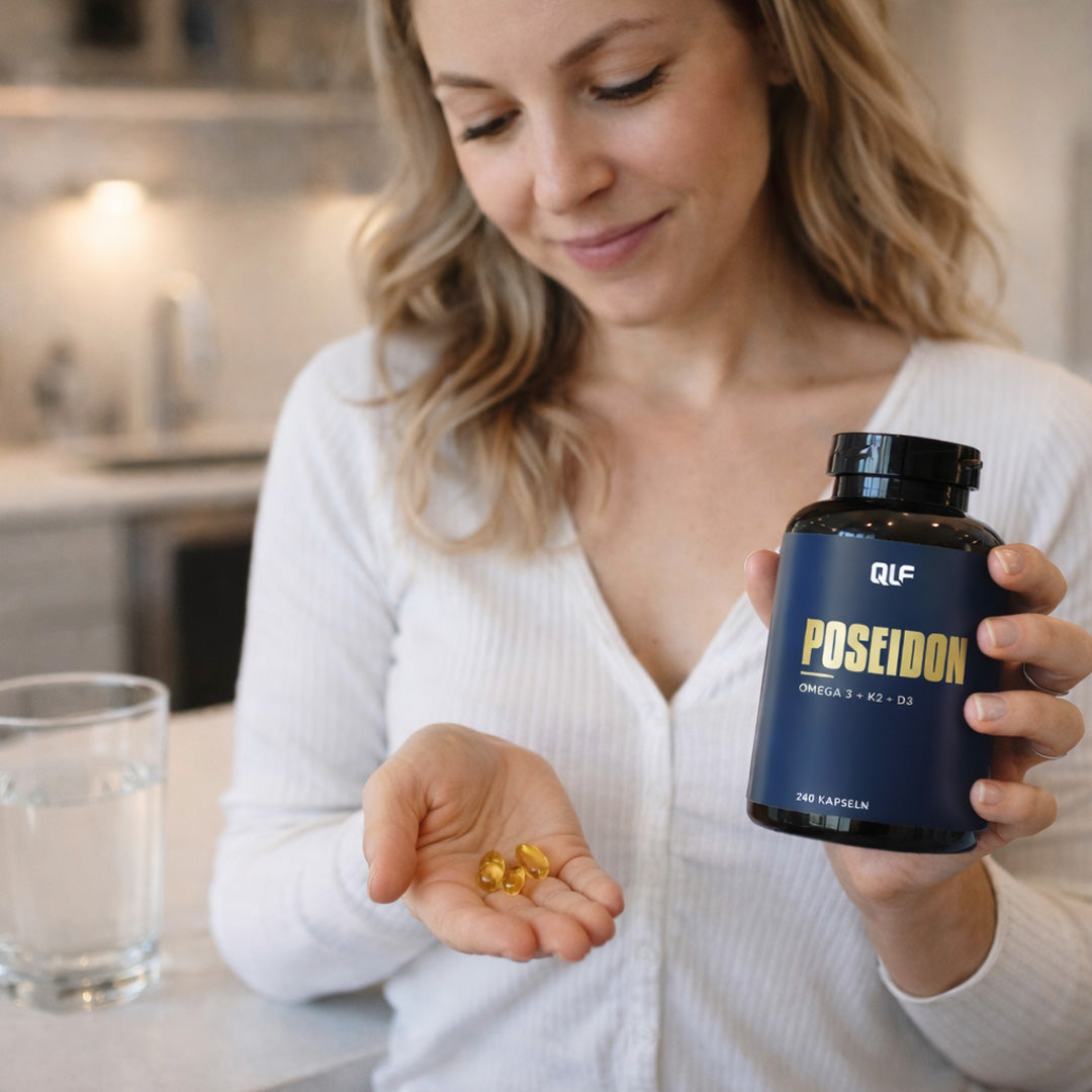 Woman in white top holding Poseidon Omega 3 supplement bottle and capsules in her hand in kitchen setting