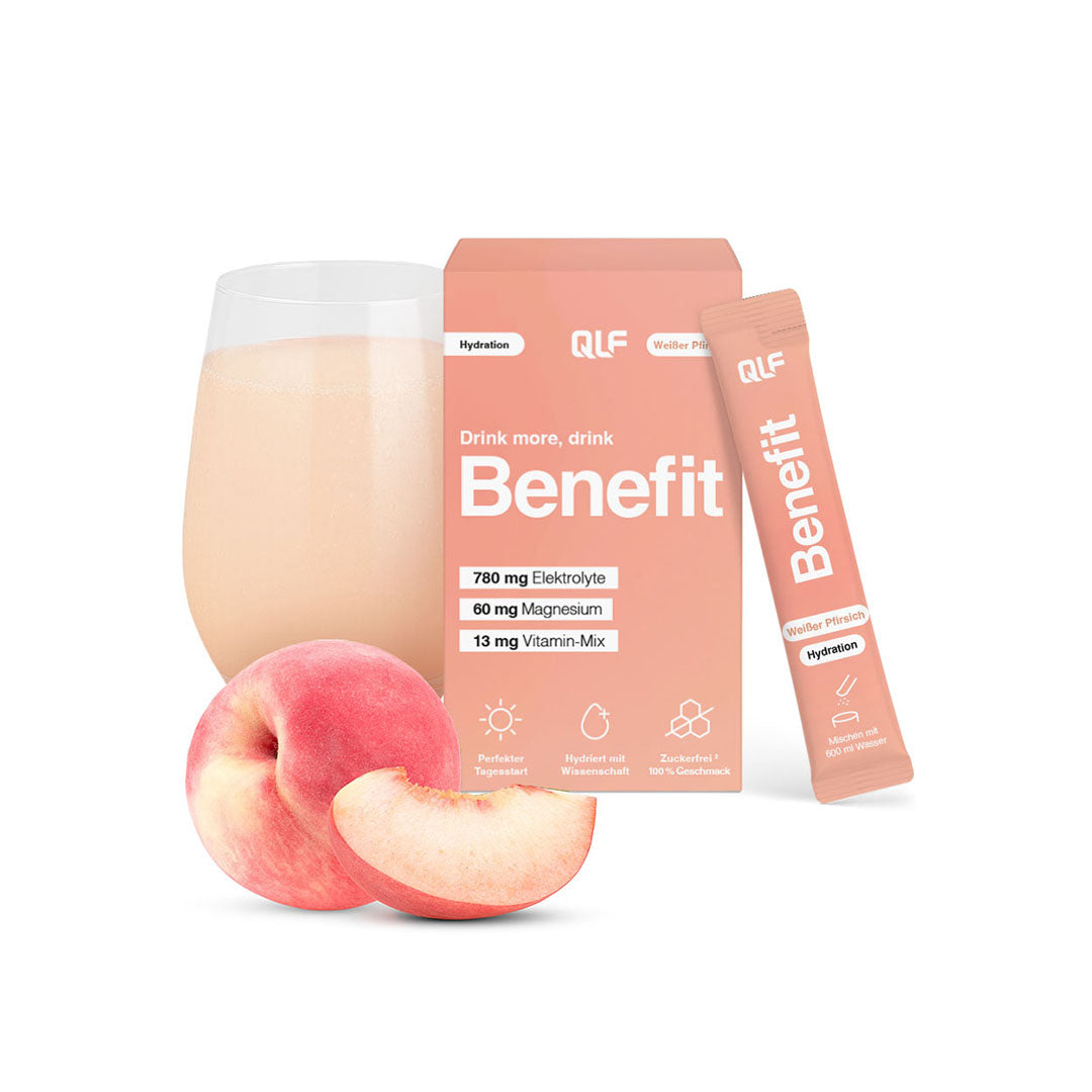 Peach hydration sachet and box beside glass of peach drink with whole and sliced peach on white background