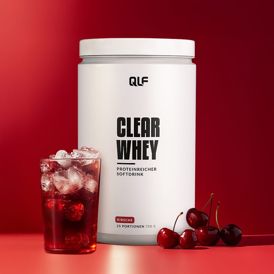 Clear Whey Isolat mit kirschigem Proteinsoftdrink, Eiswürfeln und frischen Kirschen vor rotem Hintergrund Galerie 1