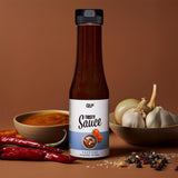 Tasty Sauce Barbecue Flasche mit 4 Kalorien pro Portion, präsentiert mit frischen Chilis und Gewürzen, Galerie 1