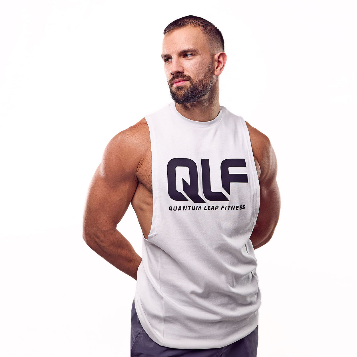 QLF Squad Tank Top (großes Logo) in weiß, Model mit seitlichem Blick, muskulöse Silhouette, Galerieposition 1