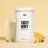 Tasty Whey Proteinpulver Banane mit Glas Shake, frischen Bananen und cremigem Geschmack, Galerieposition 1