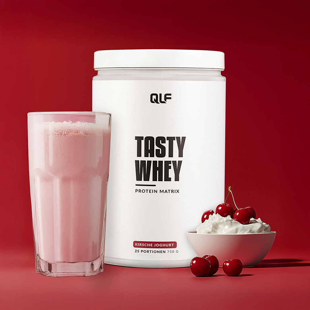 Tasty Whey Proteinpulver Kirsche Joghurt mit Proteinshake im Glas, frischen Kirschen und Joghurt auf rotem Hintergrund Galerie 1