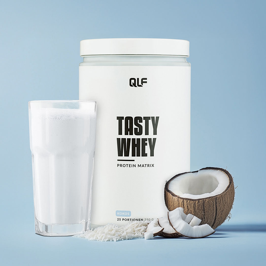 Tasty Whey Proteinpulver Kokos mit Glas Shake, frischer Kokosnuss und feinem Kokosgeschmack, Galerieposition 1
