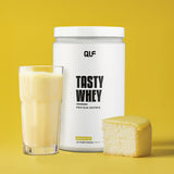 Tasty Whey Proteinpulver Lemoncake mit Shake im Glas und Stück Zitronenkuchen vor gelbem Hintergrund Galerie 1