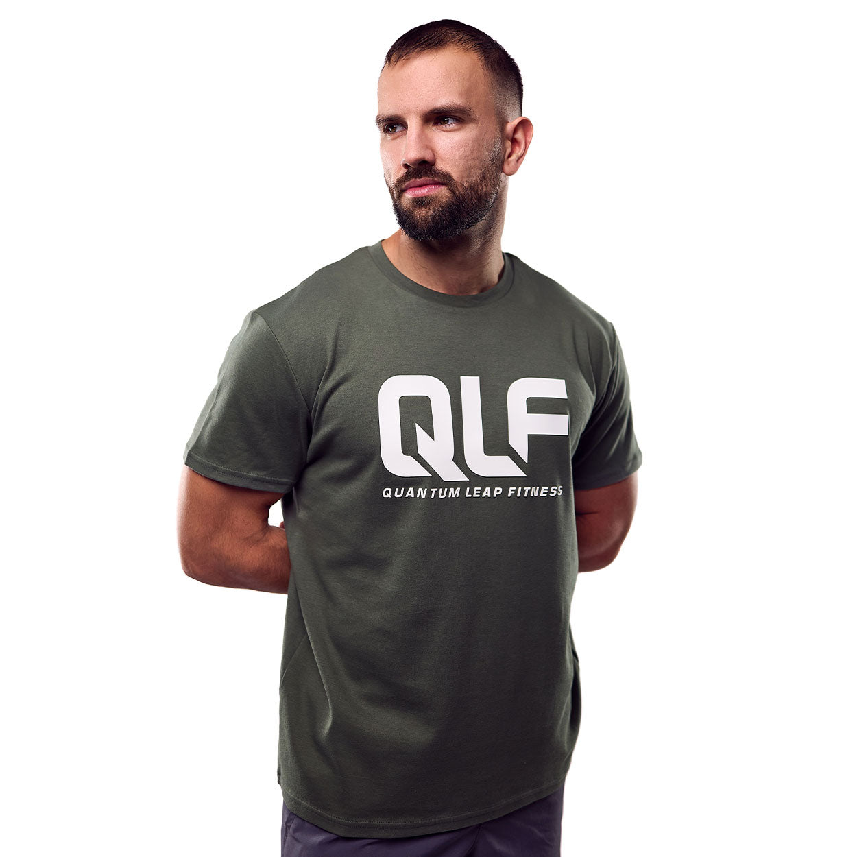 QLF Squad T-Shirt (großes Logo) in grün mit großem Quantum Leap Fitness Schriftzug, Modell seitlich stehend Galerie 1